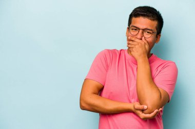 Genç İspanyol adam mavi arka planda izole edilmiş gülerek, kaygısızca, doğal duygularla.