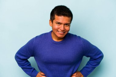 Genç İspanyol adam mavi arka planda izole edilmiş mutlu, güler yüzlü ve neşeli.