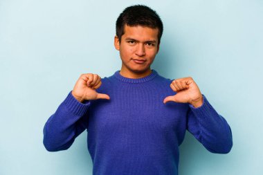 Mavi arka planda izole edilmiş genç bir İspanyol gururlu ve kendinden emin hissediyor, örnek olarak..