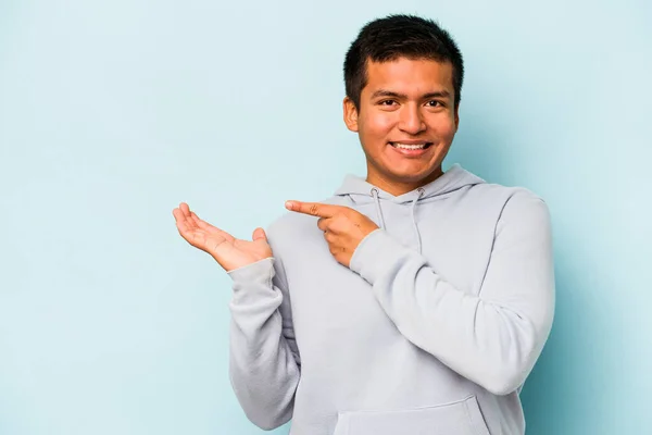 Joven Hispano Aislado Sobre Fondo Azul Excitado Sosteniendo Espacio Copia — Foto de Stock