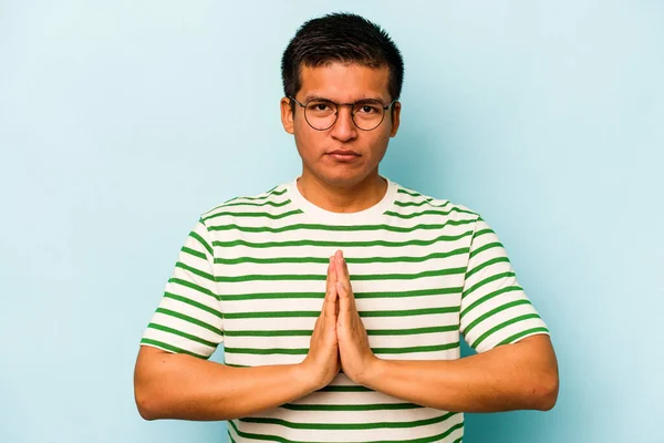 Junger Hispanischer Mann Isoliert Auf Blauem Hintergrund Betet Zeigt Frömmigkeit — Stockfoto