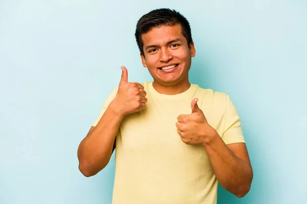 Mladý Hispánec Izolovaný Modrém Pozadí Zvedá Oba Palce Nahoru Usmívá — Stock fotografie