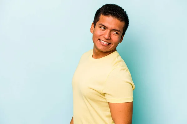 Young Hispanic Man Isolated Blue Background Looks Aside Smiling Cheerful — Stock Photo, Image