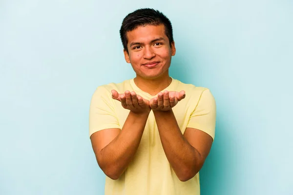 Young Hispanic Man Isolated Blue Background Holding Something Palms Offering — Stock Photo, Image