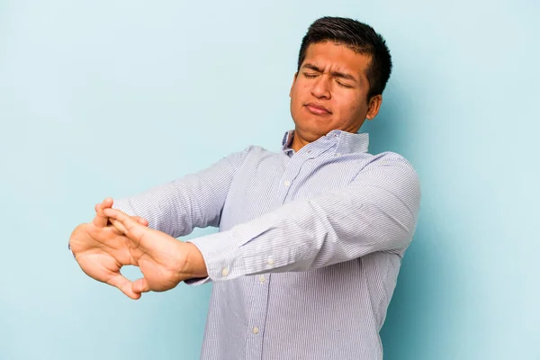 Jovem Hispânico Homem Isolado Fundo Azul Alongamento Braços Relaxado Posição — Fotografia de Stock