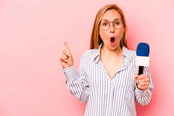 Pembe arka planda izole edilmiş beyaz bir TV sunucusu yan tarafı işaret ediyor.