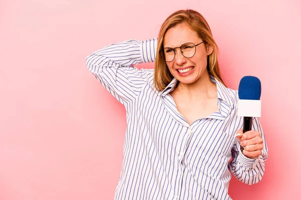 Kafkas TV sunucusu kadın pembe arka planda izole edilmiş kafasının arkasına dokunuyor, düşünüyor ve bir seçim yapıyor..