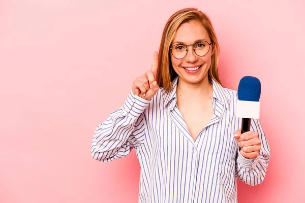 Pembe arka planda izole edilmiş beyaz TV sunucusu kadın parmak izleriyle bir numarayı gösteriyor..