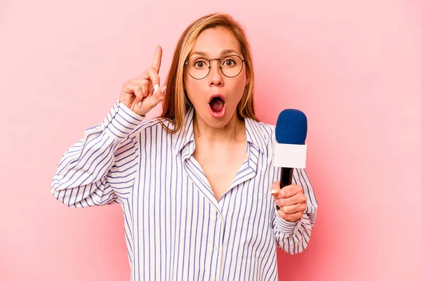 Pembe arka planda izole edilmiş beyaz TV sunucusu genç kadının bir fikri var, ilham verici bir kavram..