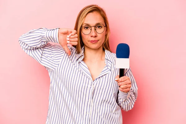 Kafkas TV sunucusu, pembe arka planda izole edilmiş, hoş olmayan bir jest gösteren genç bir kadın. Anlaşmazlık konsepti.