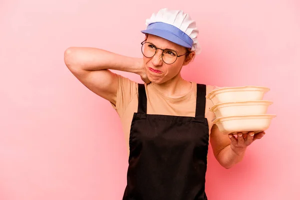 Jovem Cozinheira Voluntária Mulher Isolada Fundo Rosa Tocando Parte Trás — Fotografia de Stock