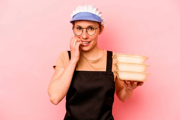 Jovem Cozinheira Voluntária Mulher Isolada Fundo Rosa Mordendo Unhas Nervosa — Fotografia de Stock