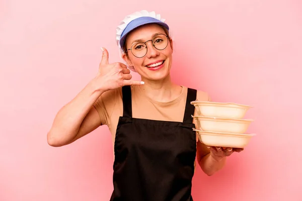 Jovem Cozinheira Voluntária Isolada Fundo Rosa Mostrando Gesto Chamada Telefone — Fotografia de Stock