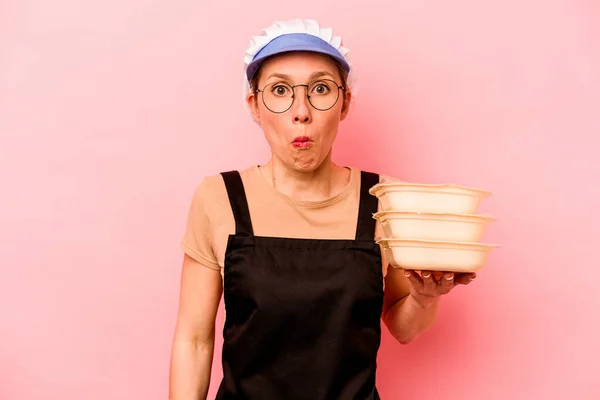 Jovem Cozinheira Voluntária Mulher Isolada Fundo Rosa Encolhe Ombros Olhos — Fotografia de Stock