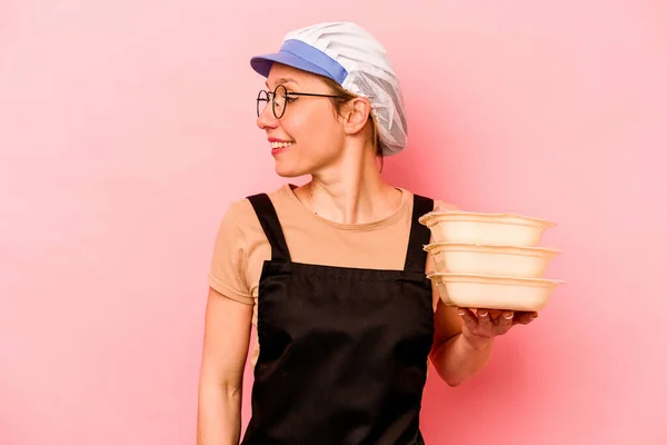 Jovem Cozinheira Voluntária Mulher Isolada Fundo Rosa Olha Para Lado — Fotografia de Stock