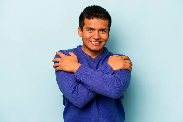 Jeune Homme Hispanique Isolé Sur Fond Bleu Câlins Souriant Insouciant — Photo