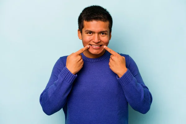 Junger Hispanischer Mann Auf Blauem Hintergrund Lächelt Und Zeigt Mit — Stockfoto
