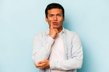 Latin kökenli genç bir adam mavi arka planda izole edilmiş. Harika bir fikri var, yaratıcılık kavramı..