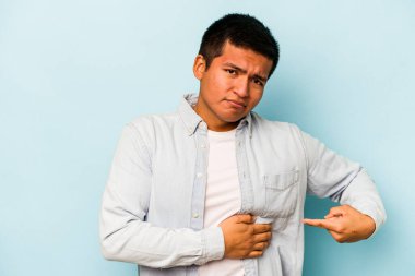 Mavi arka planda karaciğer ağrısı ve karın ağrısı çeken genç bir İspanyol..