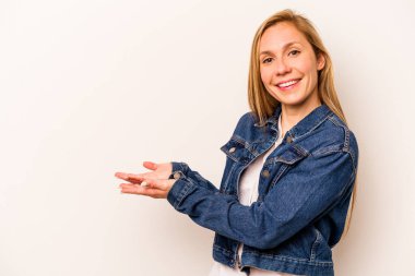 Beyaz arka planda izole edilmiş beyaz tenli genç bir kadın palmiyesinde bir kopya alanı tutuyor..