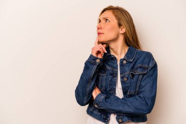 Beyaz arka planda soyutlanmış beyaz tenli genç bir kadın şüpheli ve şüpheci bir ifadeyle yana bakıyor..