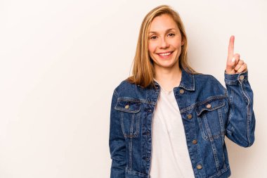 Beyaz arka planda izole edilmiş beyaz tenli genç bir kadın bir numarayı parmağıyla gösteriyor..