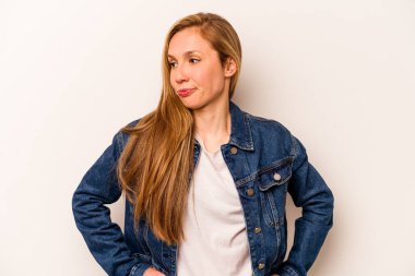 Beyaz arka planda soyutlanmış beyaz bir kadın kafası karışmış, kuşkulu ve kendinden emin değil..