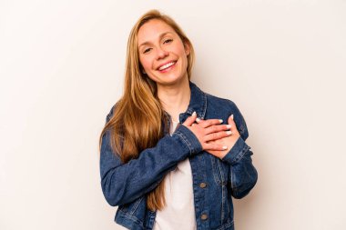 Beyaz arka planda izole edilmiş beyaz tenli genç bir kadın, dostane bir ifadeye sahip, avuçlarını göğsüne bastırıyor. Aşk konsepti.