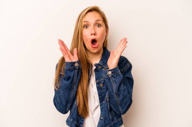 Beyaz arka planda izole edilmiş genç beyaz kadın şaşırmış ve şok olmuş..