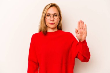 Beyaz arka planda izole edilmiş genç beyaz kadın gülümseyerek beş numarayı parmaklarıyla gösteriyor..