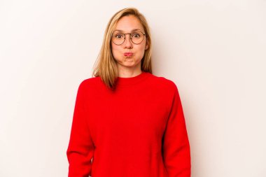 Beyaz arka planda izole genç beyaz kadın yanakları üflüyor, yorgun bir ifadesi var. Yüz ifadesi kavramı.