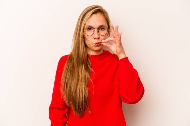 Beyaz arka planda izole edilmiş beyaz tenli genç bir kadın parmakları dudaklarında bir sır saklıyor..