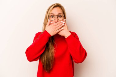 Beyaz arka planda izole edilmiş beyaz tenli genç bir kadın elleri endişeli bir şekilde ağzı örtüyor..