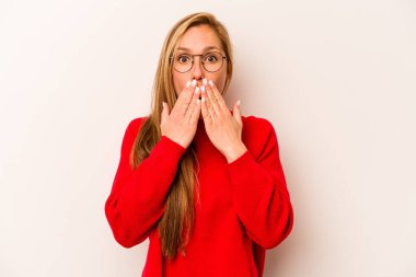 Beyaz arka planda izole edilmiş genç beyaz kadın şok olmuş, elleri ağızda, yeni bir şey keşfetmeye hevesli..