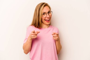 Beyaz arka planda izole edilmiş genç beyaz kadın parmaklarıyla ön tarafı işaret ediyor..