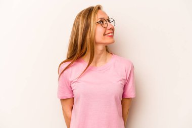 Beyaz arka planda izole edilmiş genç beyaz kadın rahat ve mutlu bir şekilde gülüyor, boynunda dişlerini gösteriyor..