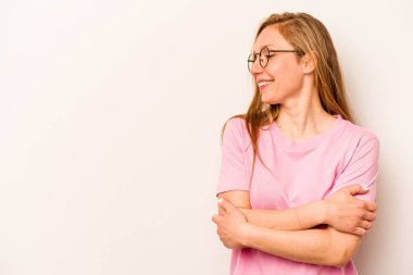 Beyaz arka planda soyutlanmış beyaz bir kadın kollarını kavuşturup gülümsüyor..