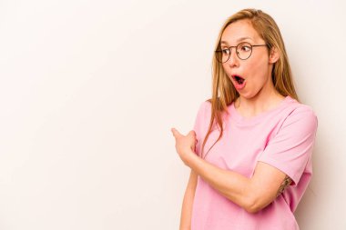 Beyaz arka planda izole genç beyaz kadın başparmak uzakta, gülüyor ve kaygısız.