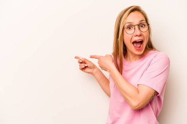 Beyaz arka planda izole edilmiş beyaz tenli genç bir kadın işaret parmağıyla işaret ederek heyecanlanıyor..