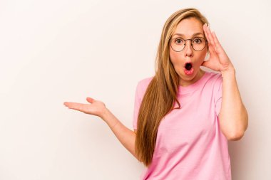 Beyaz arka planda izole edilmiş beyaz tenli genç bir kadın avuç içinin fotokopi alanından etkilenmiş..