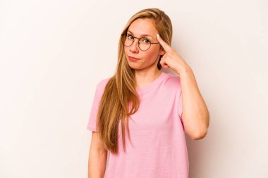 Beyaz arka planda izole edilmiş beyaz tenli genç bir kadın şakağı parmağıyla işaret ediyor, düşünüyor ve bir göreve odaklanıyor..