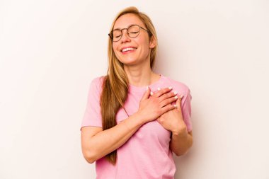 Beyaz arka planda izole edilmiş beyaz tenli genç bir kadın, dostane bir ifadeye sahip, avuçlarını göğsüne bastırıyor. Aşk konsepti.