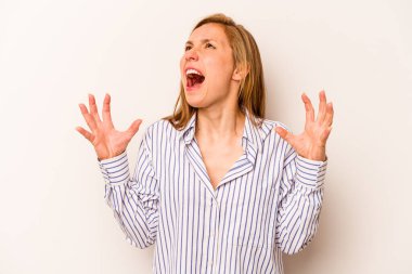 Beyaz arka planda izole edilmiş genç beyaz kadın gökyüzüne haykırıyor, yukarı bakıyor, hayal kırıklığına uğramış..