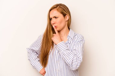 Beyaz arka planda izole edilmiş genç beyaz kadın ya sır saklıyor ya da sessizlik istiyor..