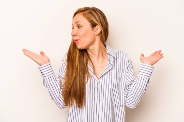 Beyaz arka planda izole edilmiş genç beyaz bir kadın. Kafası karışmış ve omuz silkiyor. Kopya alanını tutmak için..