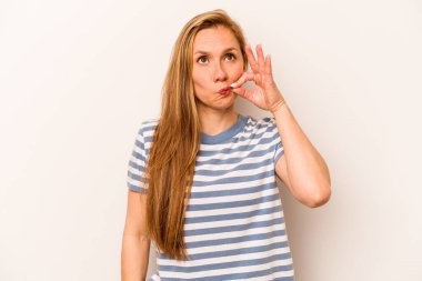 Beyaz arka planda izole edilmiş beyaz tenli genç bir kadın parmakları dudaklarında bir sır saklıyor..