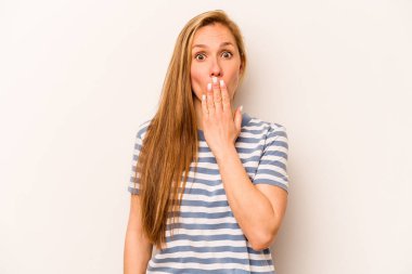 Beyaz arka planda izole edilmiş genç beyaz kadın şok olmuş, elleri ağızda, yeni bir şey keşfetmeye hevesli..