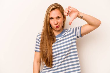 Beyaz arka planda izole edilmiş genç beyaz kadın baş parmağını aşağı gösteriyor ve hoşlanmadığını ifade ediyor..