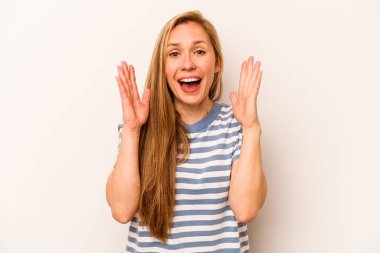 Beyaz arka planda izole genç beyaz kadın yüksek sesle gülüyor elini göğsüne koyuyor..