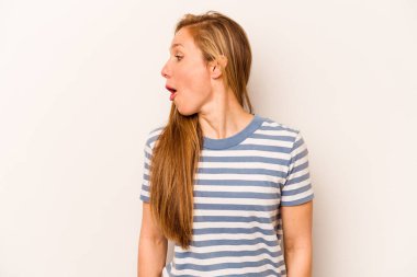 Beyaz arka planda soyutlanmış beyaz bir kadın gülümseyen, neşeli ve keyifli bir kenara bakıyor..